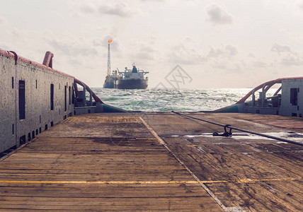 在FPSO油轮附近进行动态定位DP作业期间的起锚拖轮供应AHTS船舶正在做静态拖船起吊图片