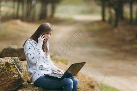 年轻关注的女商人或学生穿着休闲服坐在石头上图片