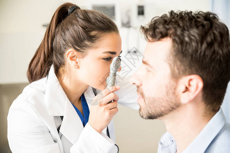 带眼透镜的光学医生检查男病人在医图片