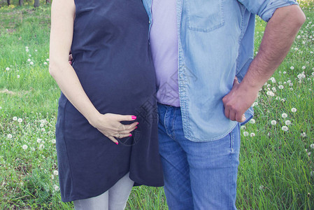 期待父母在怀孕的腹部拥抱和手牵的剪影怀孕生育和图片
