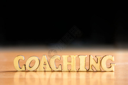 木制字母的coaching一词木刻在桌子上背景图片