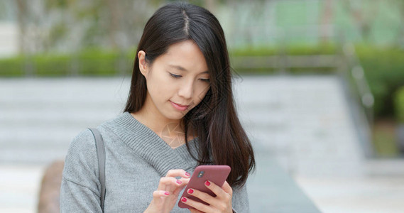 女人在户外看手机图片