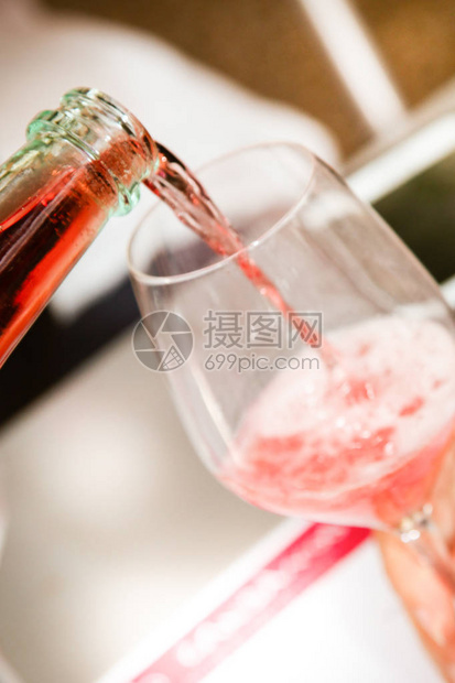 将红酒从瓶子倒到葡萄酒杯里图片