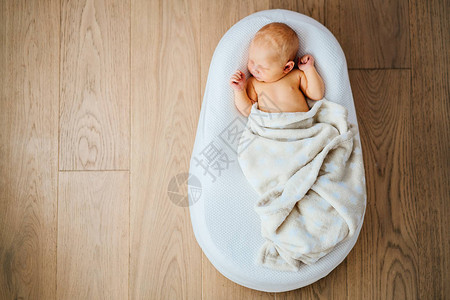 刚出生的婴儿安静地睡在特殊的骨科床垫婴儿茧中背景图片