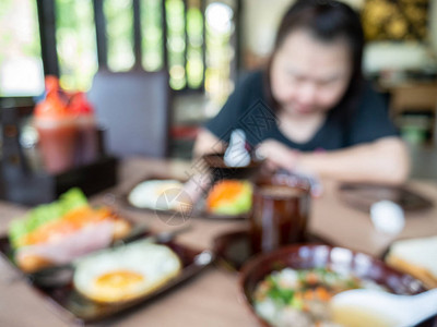 将未查明身份的妇女与早餐煎盘软锅米放在桌上的早餐成套图片