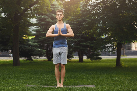 高尚的男子在公园里练瑜伽和放松图片