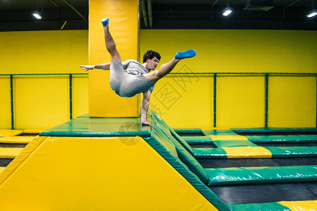 蹦床上跳跃者进行复杂的技操练在蹦图片