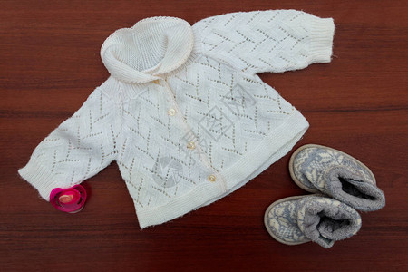 婴儿衣服鞋和木制背景的杂物图片