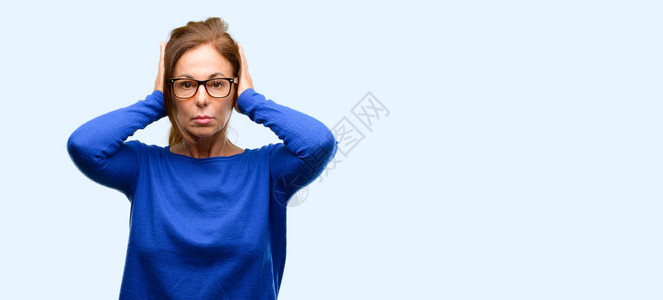 中年妇女穿着羊毛衫和戴眼镜的耳朵无视恼人的巨响图片