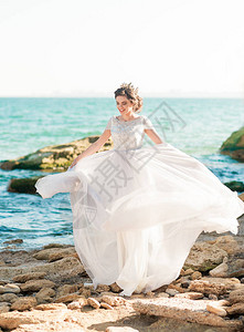 美丽的新娘穿着豪华婚纱与海边的花束欢快的新娘跳舞才开心婚纱图片
