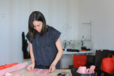 欧洲手工业妇女在家里做粉色皮革钱包图片