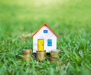 房屋模型和草地硬币用于金融和银行业务概图片