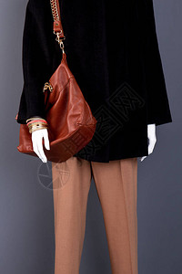 玉饰品女棕色手袋和长裤模特的高级服装和饰品灰色背景有背景