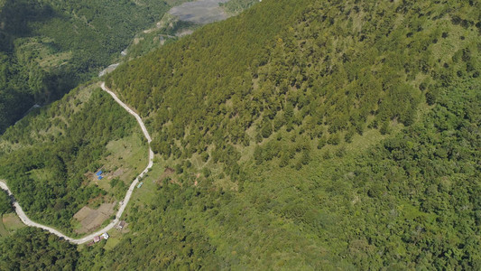 山曲线是沿着覆盖着绿色森林和植被的山脉和丘陵坡度的道路菲图片