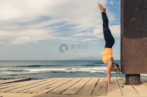 在瑜伽姿势海景海滩和木制人行道上冥想的女人动机和鼓舞人心的夏季海景观在自然概念中的户外图片