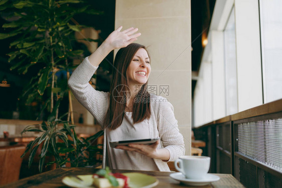 女人坐在咖啡店的餐桌旁图片