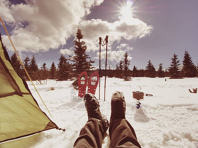 男人放松从野营帐篷入口到雪景的冬季景观旅行生活方式概念图片