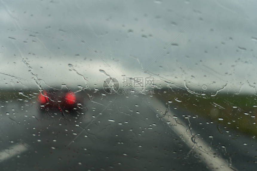 高速公路上的一个雨天和一辆经过的汽车图片