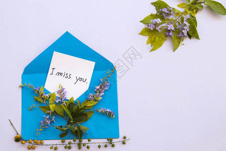 我想念你的留言卡笔迹在蓝信封和紫花安排在背景图片
