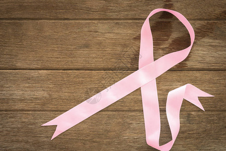 粉色丝带符号贴在木制背景上粉色丝带胸图片
