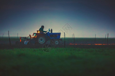 农民在拖拉机上夜间用播种床耕图片