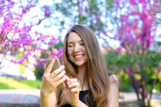 妇女通过带有鲜花背景的手语与朋友聊天图片