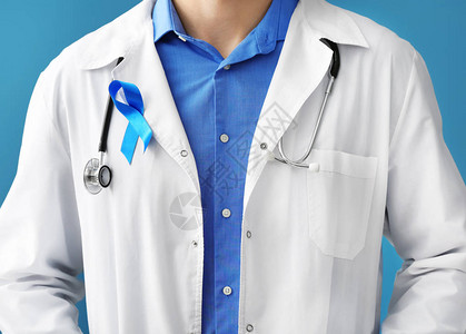 具有彩色背景的象征蓝色丝带的医生图片