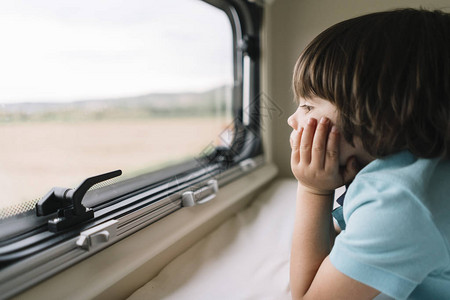 从房车窗外窥视的小男孩图片
