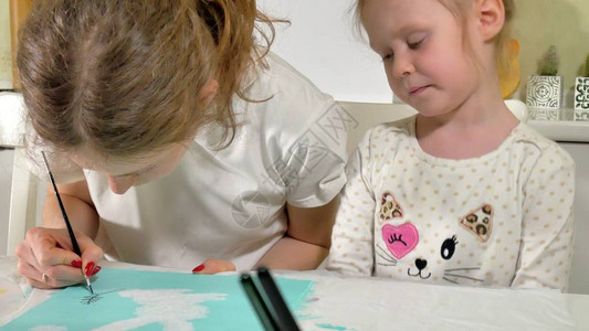 母亲和孩子用彩色刷子画儿童游戏会影响早期儿童的图片