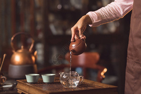 女人的手从茶壶里倒茶图片