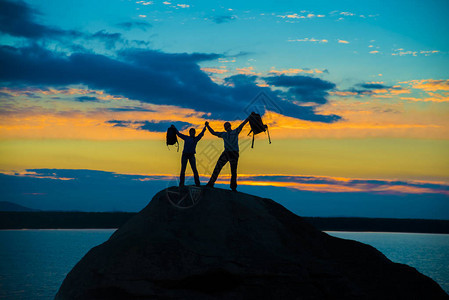 幸福的情侣们一起站在山峰上用双图片