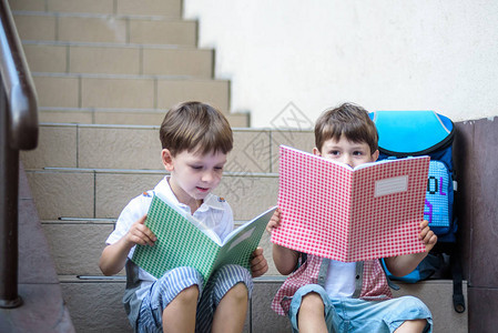 孩子们回到学校假期后新学年开始两个男孩朋友在上学的第一天背着书包和书上课开始幼儿园和学龄背景图片