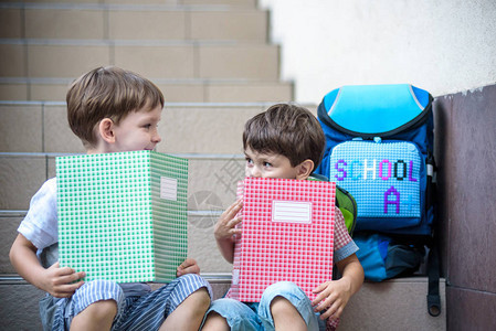 孩子们回到学校假期后新学年开始两个男孩朋友在上学的第一天背着书包和书上课开始幼儿园和学龄背景图片