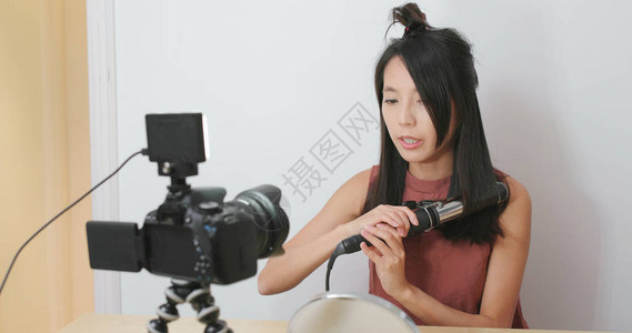女在数码相机前展示发卷的头发图片