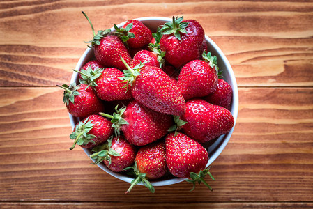 新鲜成熟的草莓在木制图片