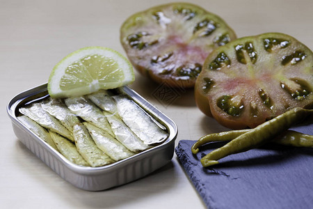 开胃菜罐头沙丁鱼樱桃西红柿绿色辣椒和石板图片