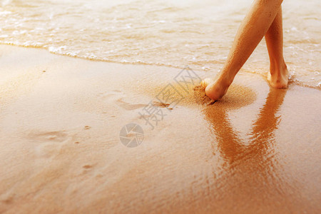 女孩站在海边的沙滩上的腿图片