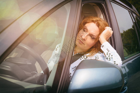 坐在车里的无聊女人在交通堵塞中图片