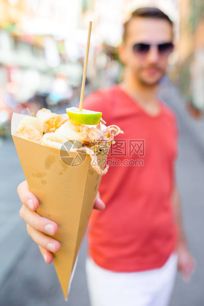 意大利街头食品在男手中烤海鲜鱼虾图片