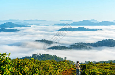 站在高山风景秀丽的农村家乡的剪影年轻人在早晨山谷雾笼罩的山脉若隐现为越南本土的图片