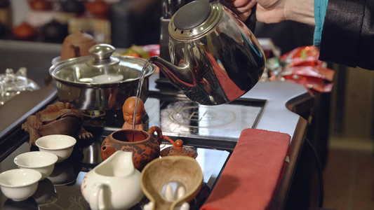 茶道制茶师将开水倒入茶壶图片