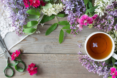 木桌上的鲜花和茶杯图片