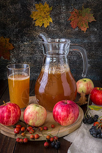 新鲜的苹果汁在木制背景上的脱图片