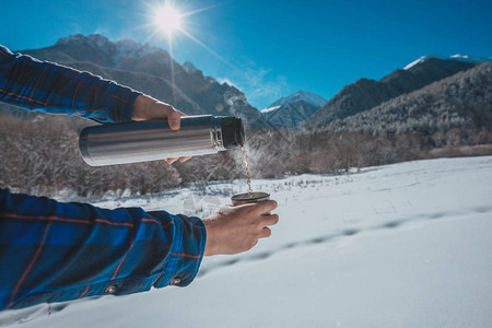 在雪山上拿着保温瓶的男人图片