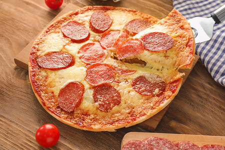 用抹刀吃一块美味的意大利辣香肠披萨图片