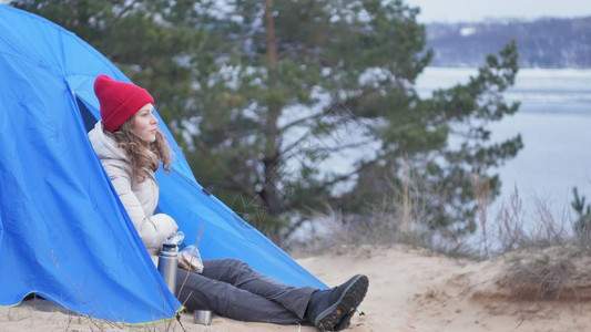 穿着红色帽子的迷人年轻女游客坐在旅游帐篷里图片