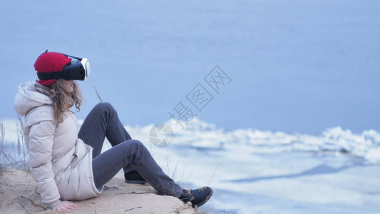 身戴红色帽子的迷人年轻女游客坐在海岸上图片