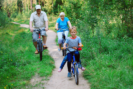 活跃的老年夫妇与孩子在大自然中骑自图片