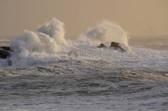 在日落的大风雨如磐的波浪飞溅图片