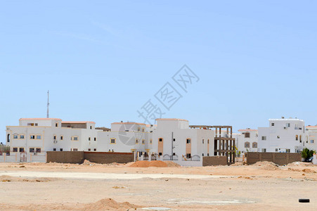 沙漠中的白色阿拉伯长方形房屋窗户以黄沙图片